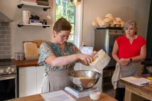 Support local with Feast On | A baker measures ingredients on a scale in a kitchen