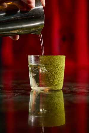 Vesper Bar Bangkok | A hand pours the Matcha Negroni cocktail Vesper Bar Bangkok | A hand pours the Matcha Negroni cocktail