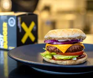 A NotCo burger on a plate and a NotCo burger box in the background
