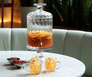 Punch recipes and big batch cocktails | Robin Goodfellow's The Ridge Hill Punch served in a drink dispenser with two glasses