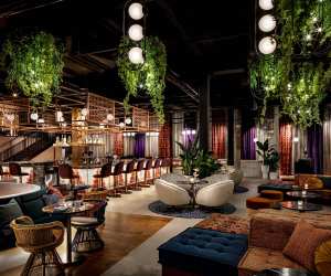 The stunning lounge area with plants, plush seating and a bar at Skylight Rooftop at W Toronto
