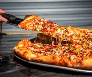 Toronto pizza | Lifting a slice from a Windsor-style pizza at Ambassador Pizza Co.