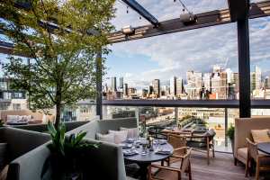 Best patios in Toronto | Lush decor and lounge seating at Harriet's rooftop at 1 Hotel Toronto