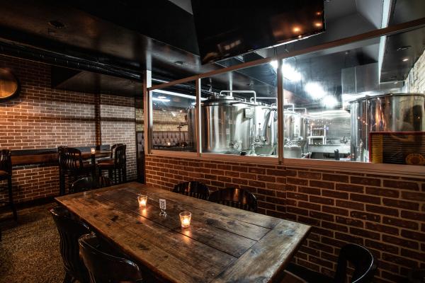 Happy hours in Toronto | A table with a view of the brewery tanks at Folly Brewpub
