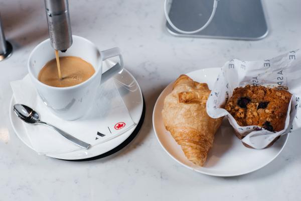 Coffee, a croissant and a muffin inside the Aspire | Air Canada Café at Billy Bishop Toronto City Airport