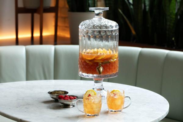 Punch recipes and big batch cocktails | Robin Goodfellow's The Ridge Hill Punch served in a drink dispenser with two glasses