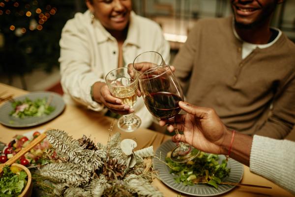 People toast with wine at a festive dinner table