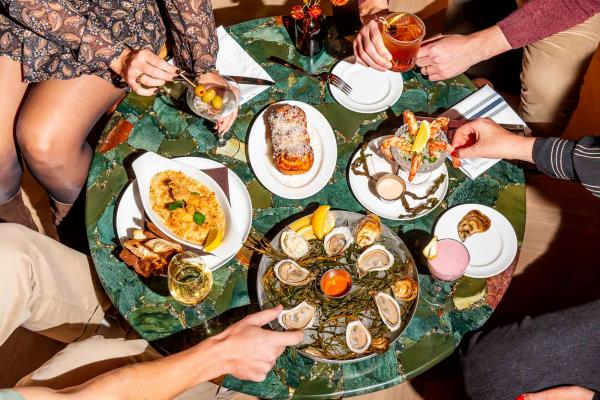 Best new Toronto restaurants | People grabbing at a spread of dishes at The Joneses restaurant in Toronto