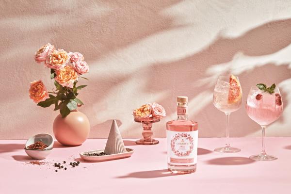 Pink cocktails | A Ceder's Rose bottle surrounded by roses and two pink mocktails