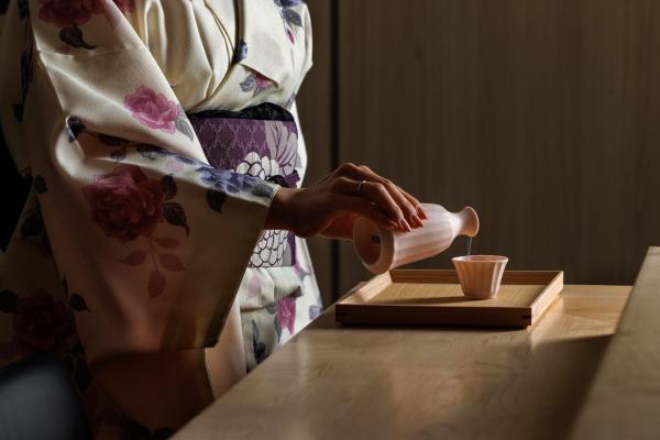 Sushi Yugen omakase in Toronto | A host in a kimono pouring sake