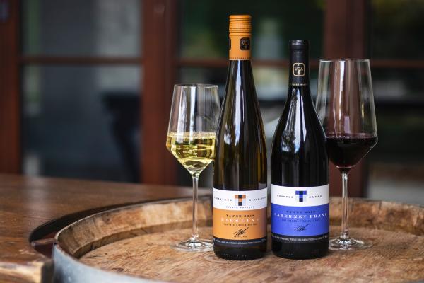 Best wineries in Beamsville | A wine glass and two bottles on a barrel at Tawse Winery