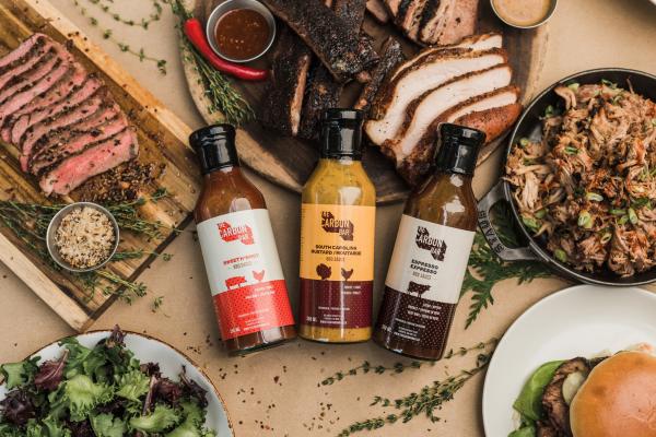 Win a Shop Carbon Bar gift card | A spread of meat, chicken, burgers and BBQ sauce from Carbon Bar