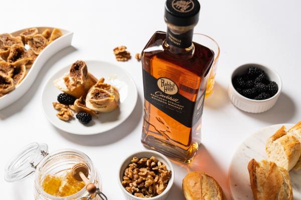 Rabbit Hole Kentucky bourbon on a table with nuts, blackberries, honey and bread Rabbit Hole Kentucky bourbon on a table with nuts, blackberries, honey and bread