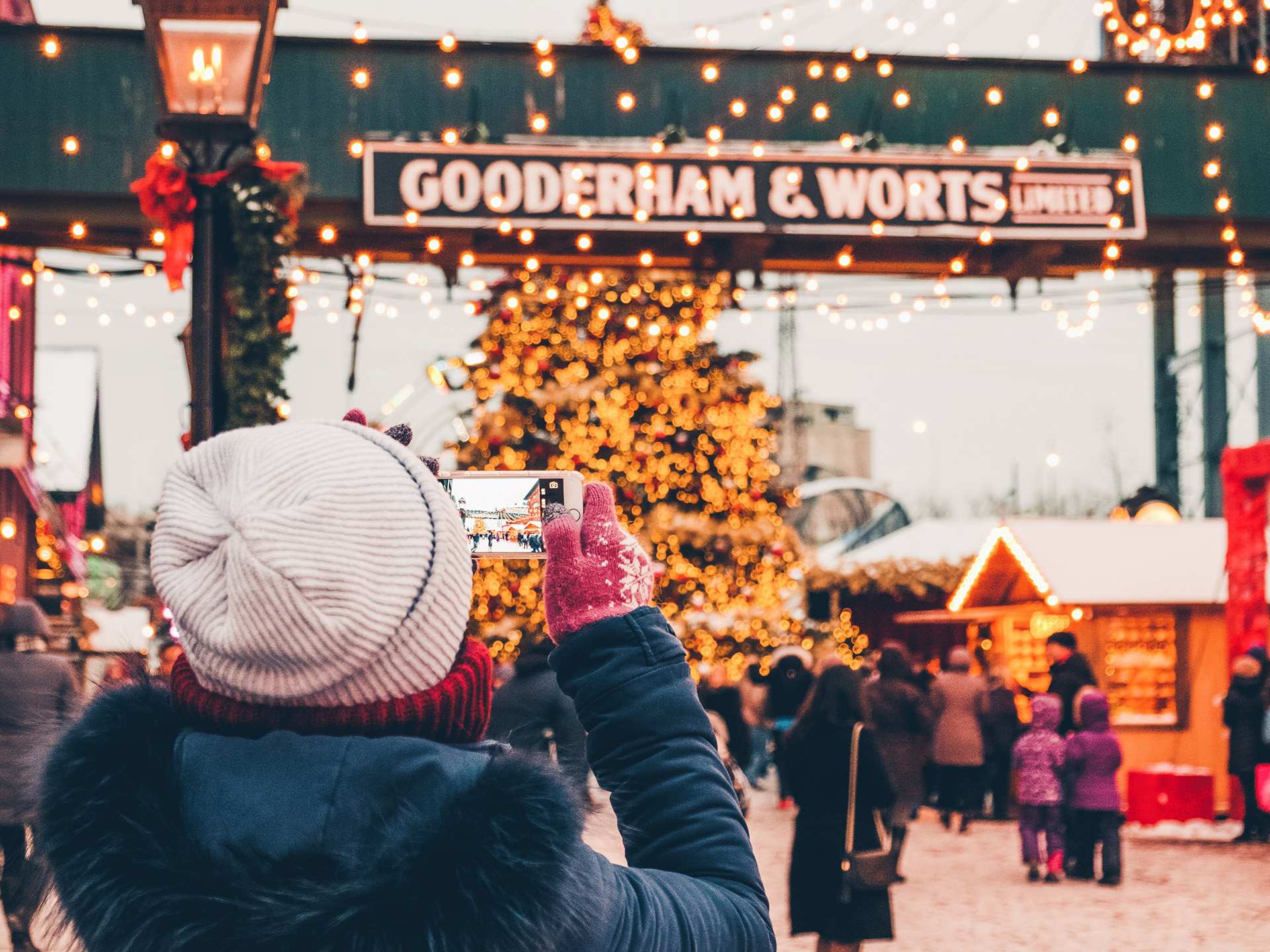 Toronto Christmas markets | Person taking a picture of the tree at Distillery Winter Village Toronto holiday pop-up