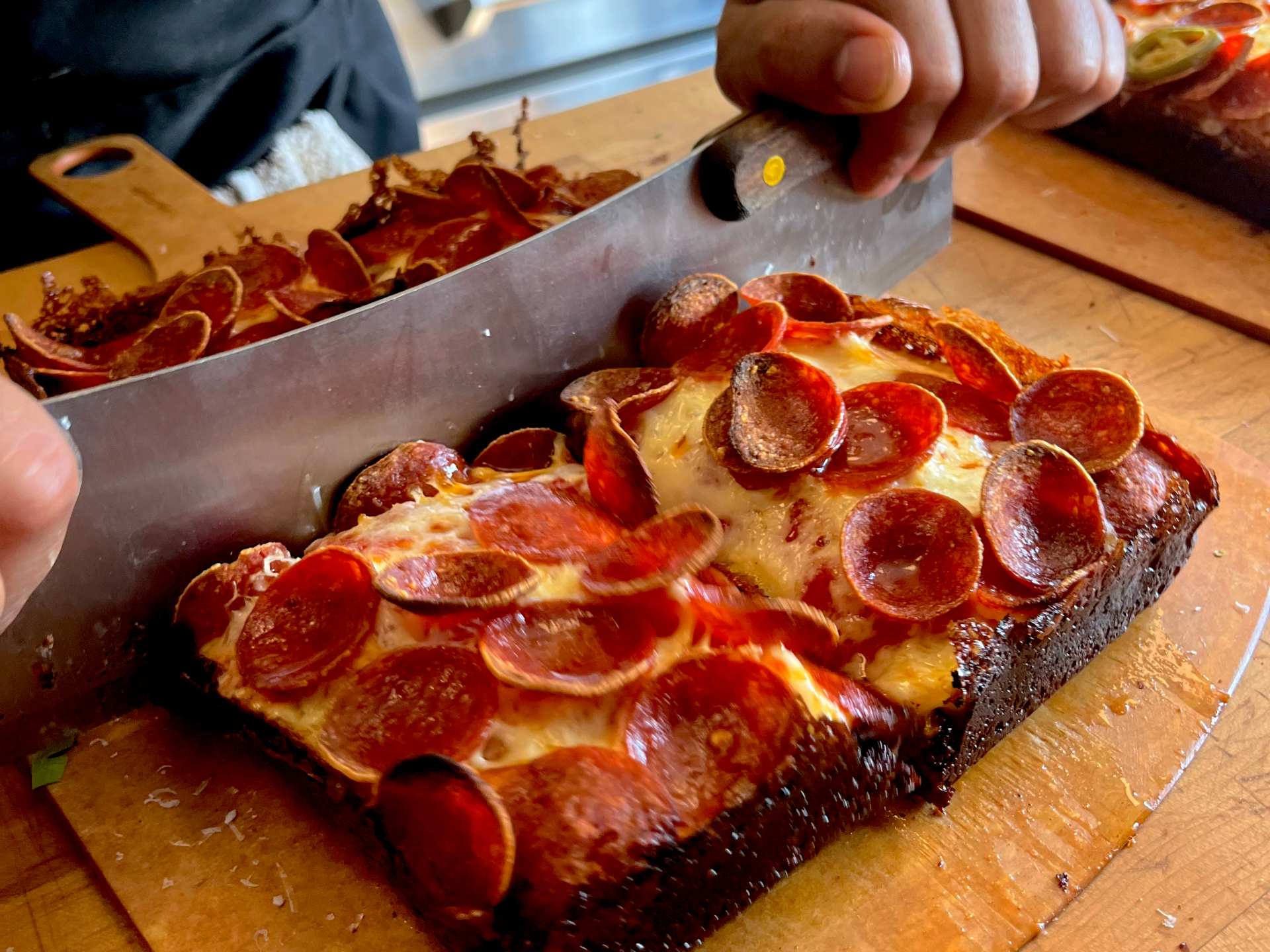 Slicing a Double Trouble pizza at Slowhand Sourdough Pizza