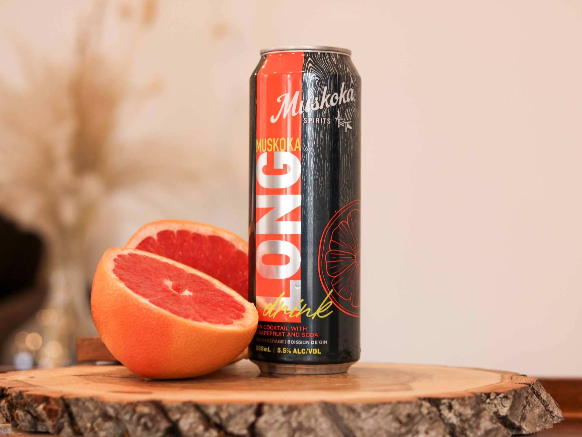 Muskoka Long Drink can on a wooden table with sliced grapefruit