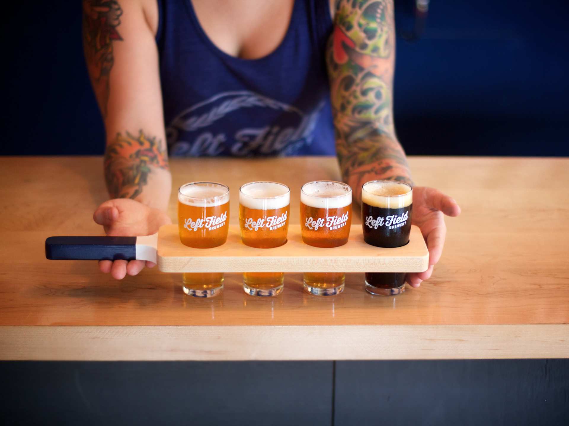 Best breweries in Toronto | A person holding a flight of three beers at Left Field Brewery
