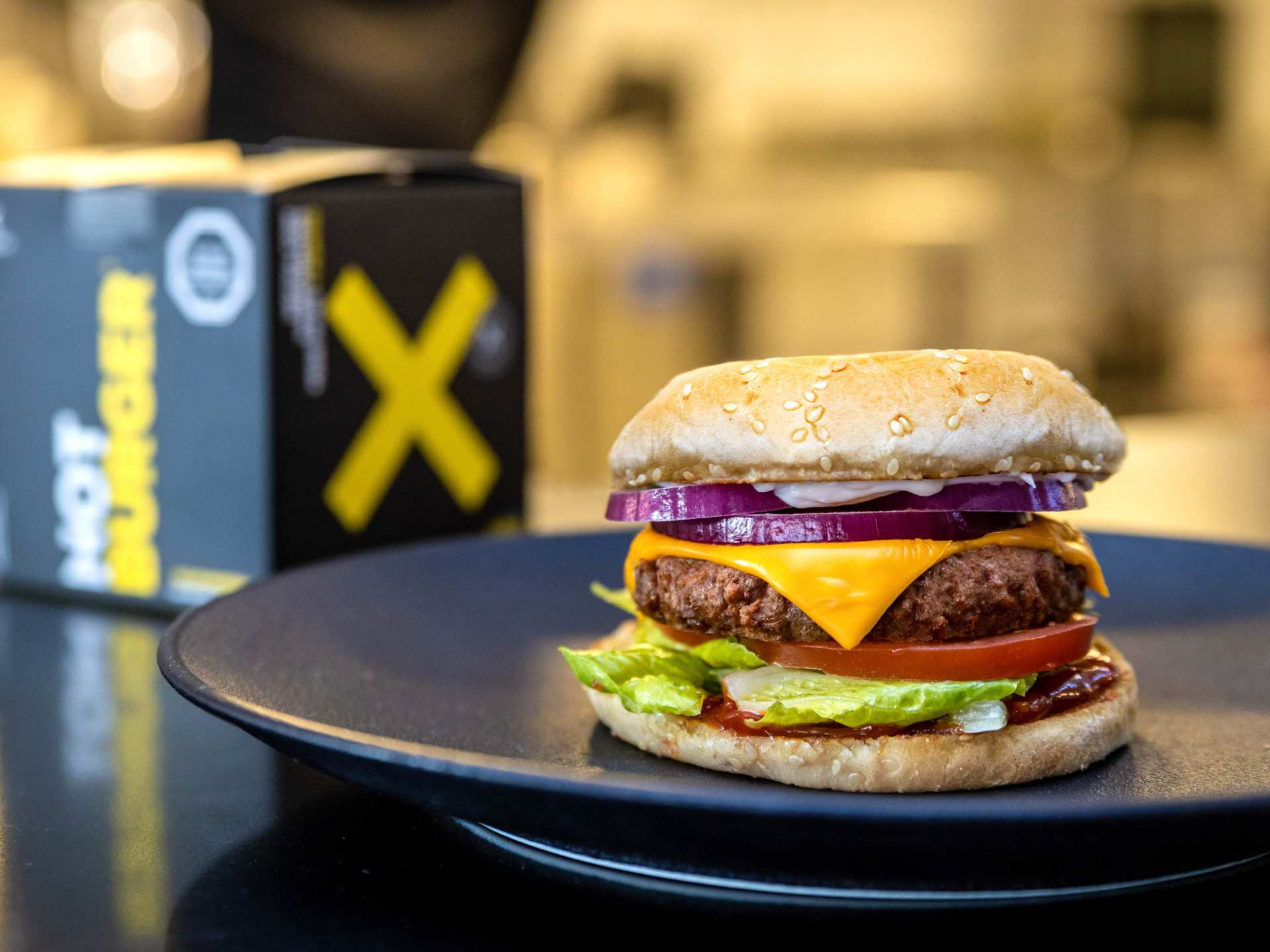 A NotCo burger on a plate and a NotCo burger box in the background