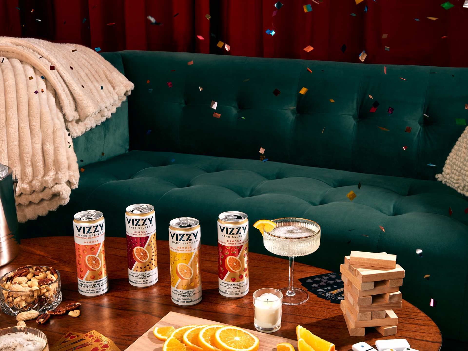 Cans of Vizzy with a green couch, snacks, games and confetti