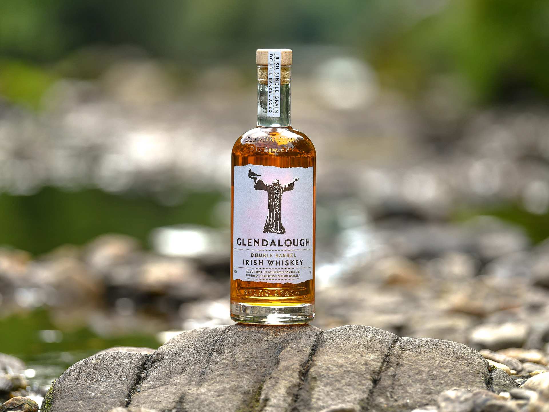 A bottle of Glendalough Double Barrel Irish Whiskey in a nature setting