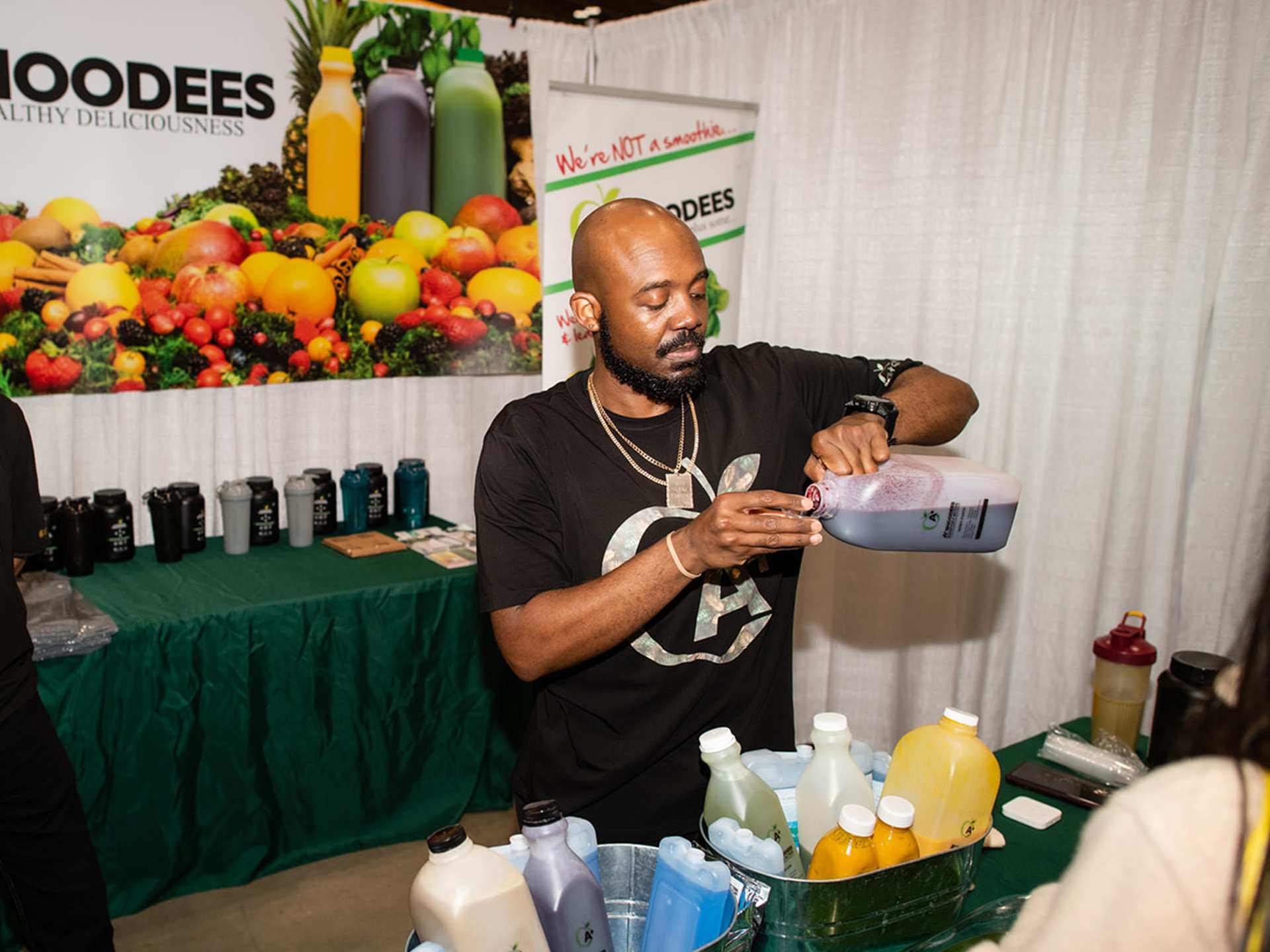 A vendor pouring out a smoothie sample at Planted Expo Toronto