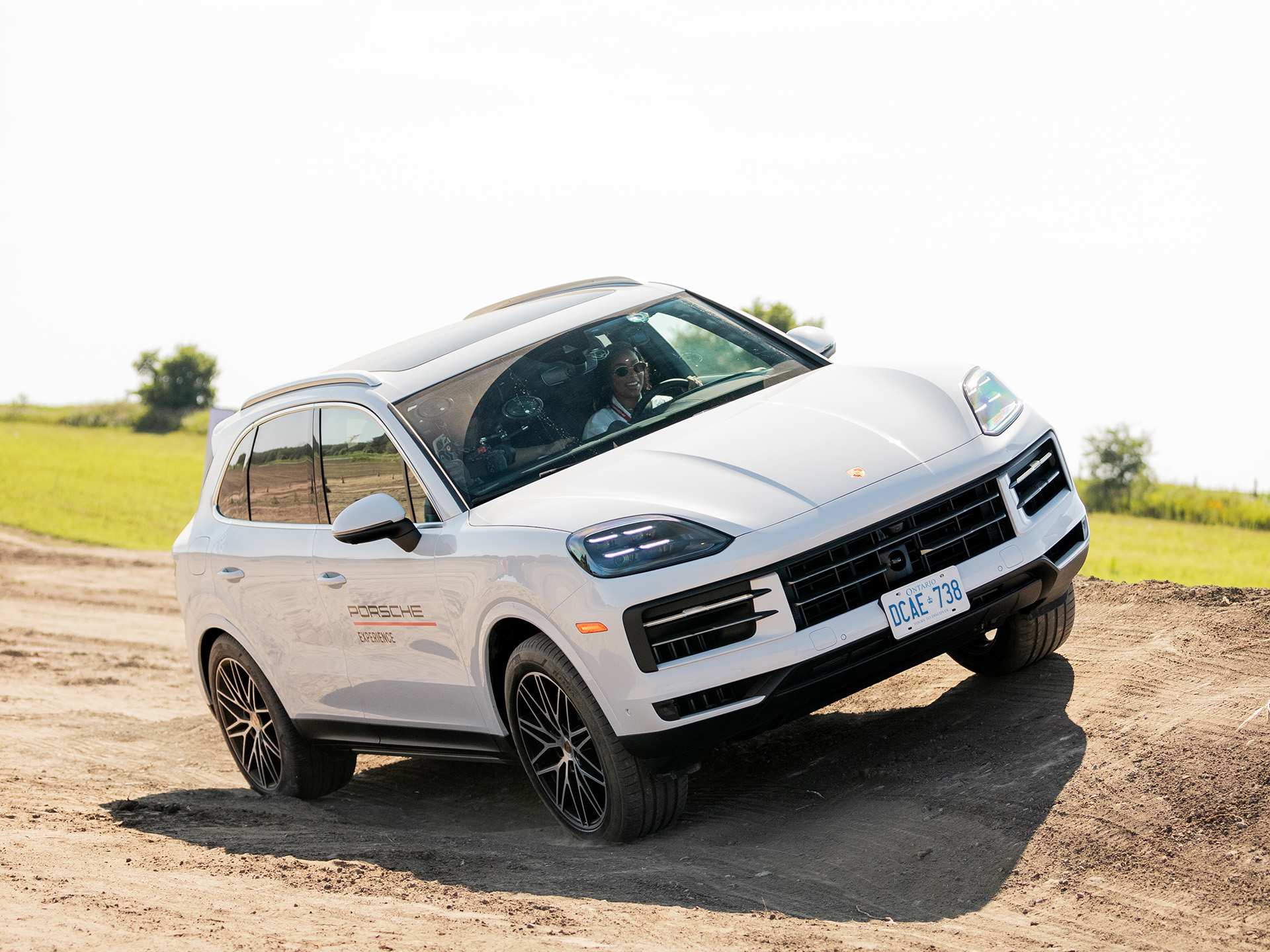 A white Porsche Cayenne on a hill