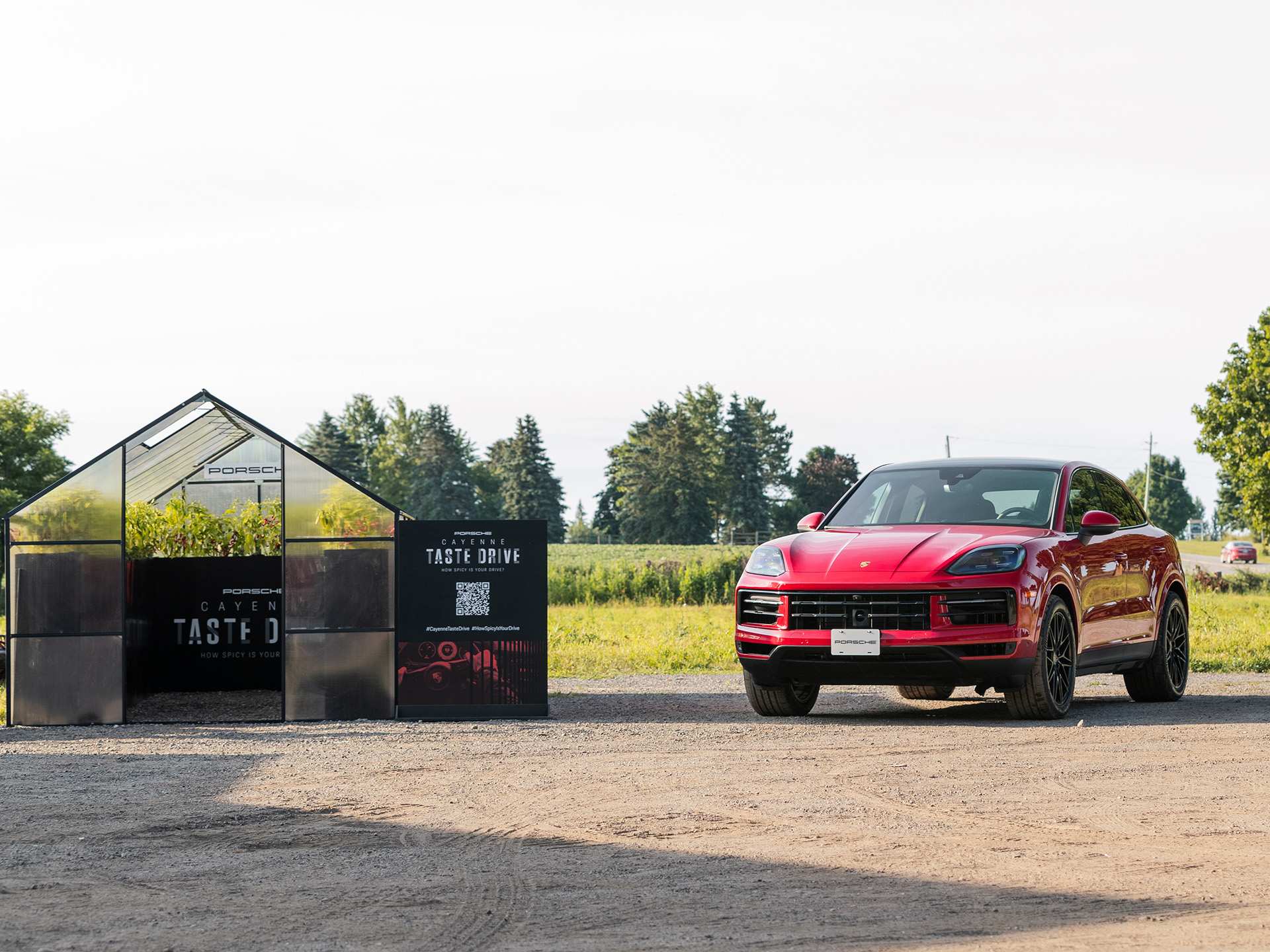 A red Porsche Cayenne beside the Taste Drive greenhouse