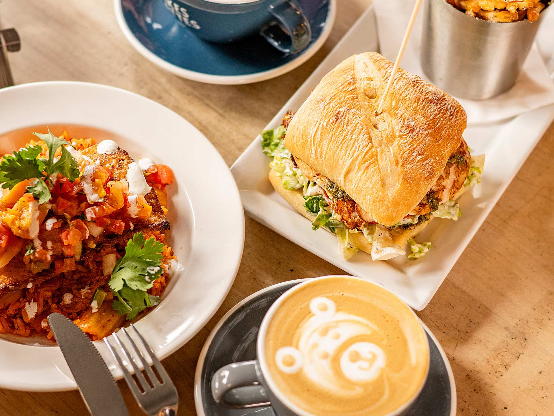 The best cafes in Toronto | A latte, sandwich and side dish at Snakes & Lattes