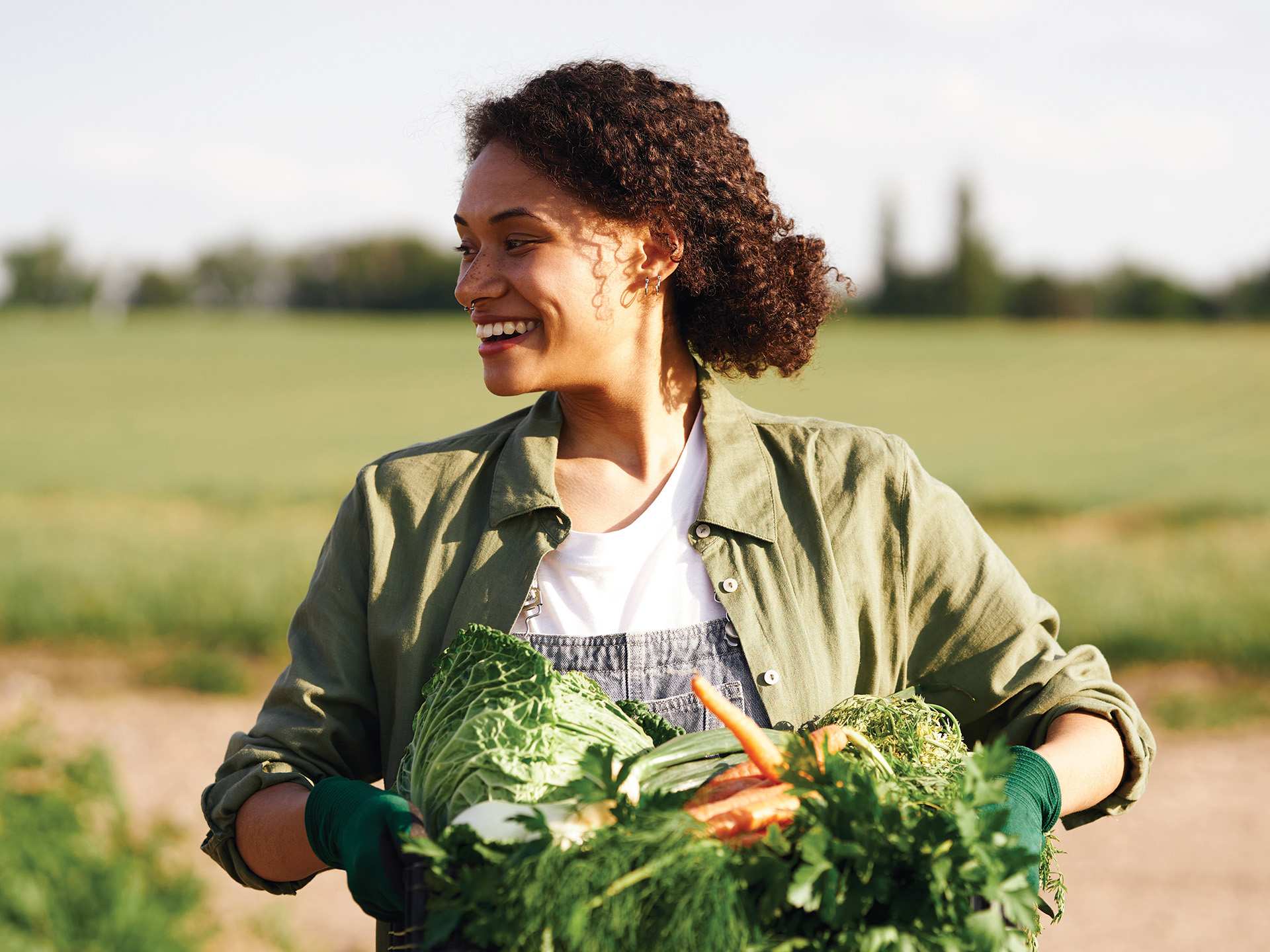 A woman holding a bundle of carrots