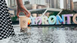 The best bubble tea in Toronto | a milk tea from Tika in front of the Toronto sign at Nathan Phillips Square