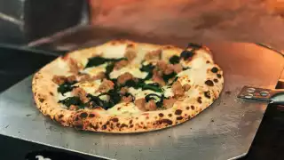 A pizza coming out of the authentic wood burning oven at La Fontana, one of the best Elora restaurants