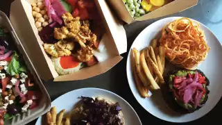 Takeout boxes filled with plant-based food from SweetChops, vegan food delivery in Toronto