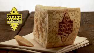 Grana Padano cheese on a rustic wood table