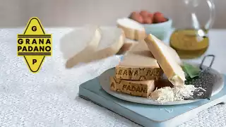 Grana Padano cheese shredded on a blue plate