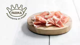 Prosciutto di Parma on a white wooden table