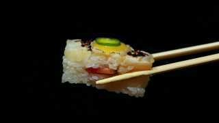 Sushi types and how to eat sushi | Chopsticks hold a piece of yellowtail oshi at Minami Toronto