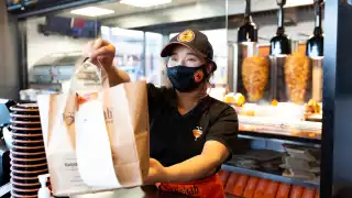 The best new restaurants in Toronto | Staff hand a takeout order over the counter at German Doner Kebab