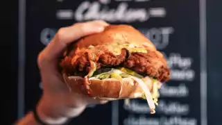 The best fried chicken sandwiches in Toronto | Someone holds up a sandwich from Knuckle Sandwich