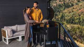 Win a Traeger Pro 575 Grill | A young couple cooks on a Traeger Grill