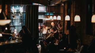 Restaurants and bars with live music in Toronto | Guests at the bar watch a small band playing inside Lapinou