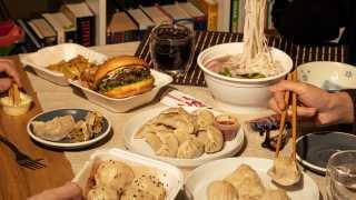 An assortment of cheap eats from different restaurants including noodles, dumplings and a burger