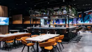Tables in front of the bar at the Aspire | Air Canada Café at Billy Bishop Toronto City Airport
