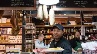 Kimpton Saint George | A man serving a tray full of food at a local restaurant