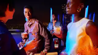 People at a rooftop party enjoying glasses of Martell Cordon Bleu cognac People at a rooftop party enjoying glasses of Martell Cordon Bleu cognac