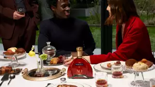 Martell Cordon XO cognac on the dinner table with a couple in the background Martell Cordon XO cognac on the dinner table with a couple in the background
