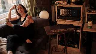 Serena Ryder sitting in her home studio with a can of Libra non-alcoholic beer