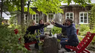 Four people enjoying glasses of wine at a beautiful Québec vineyard