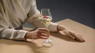 G. H. Mumm | A woman in a cream coloured blouse holds a glass of G.H. Mumm champagne