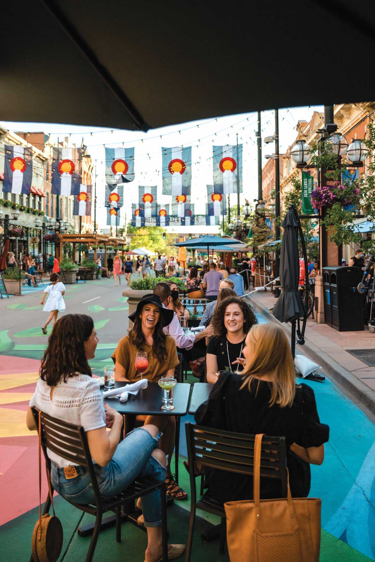People sit on a patio in Larimer Square in Denver, Colorado