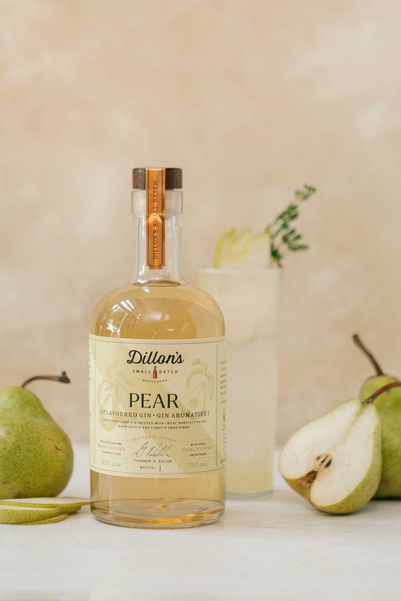 A bottle of Dillon's Pear Gin sits in front of a cocktail